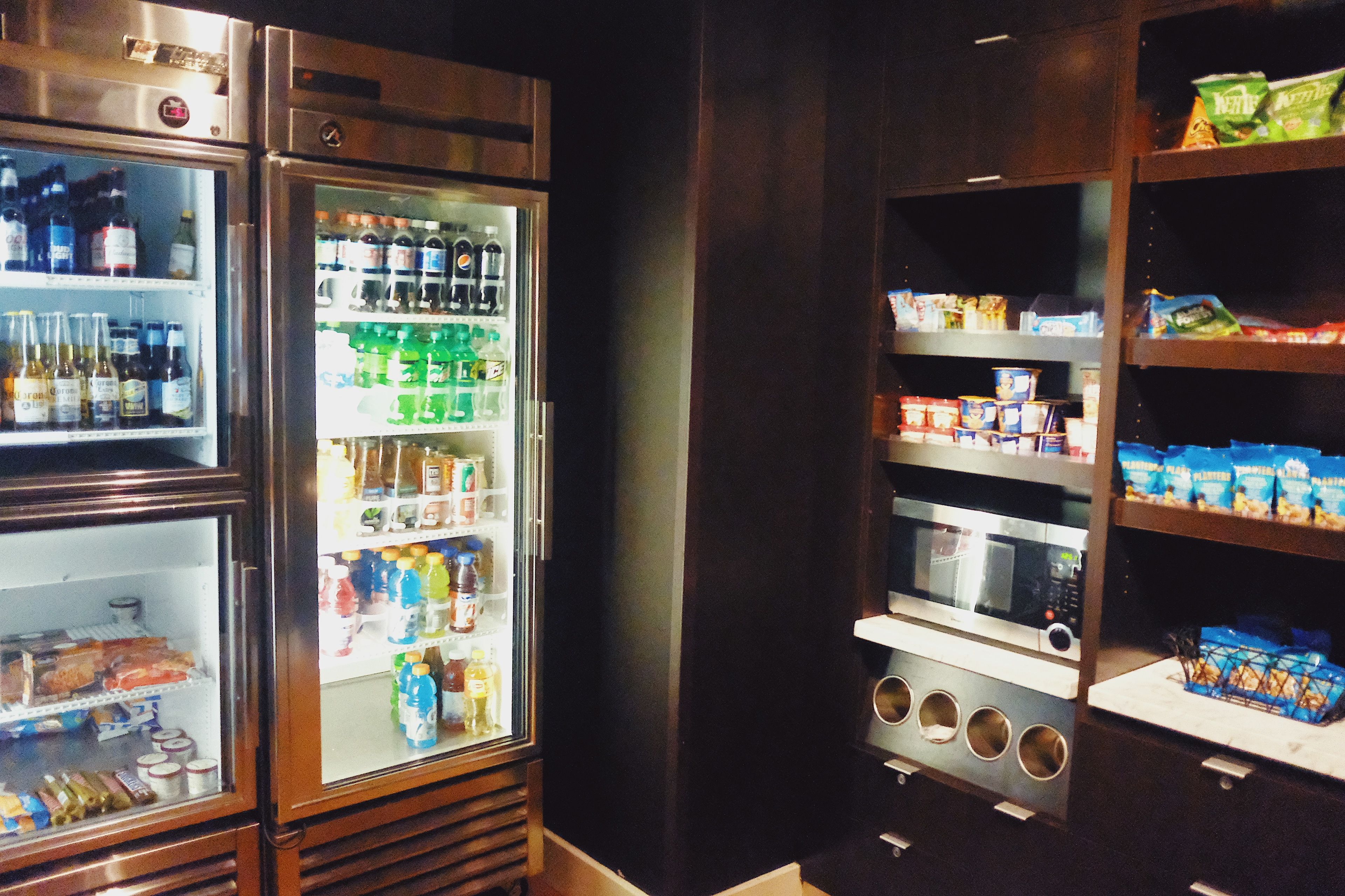 A commercial kitchen with a microwave, oven, and refrigerator.