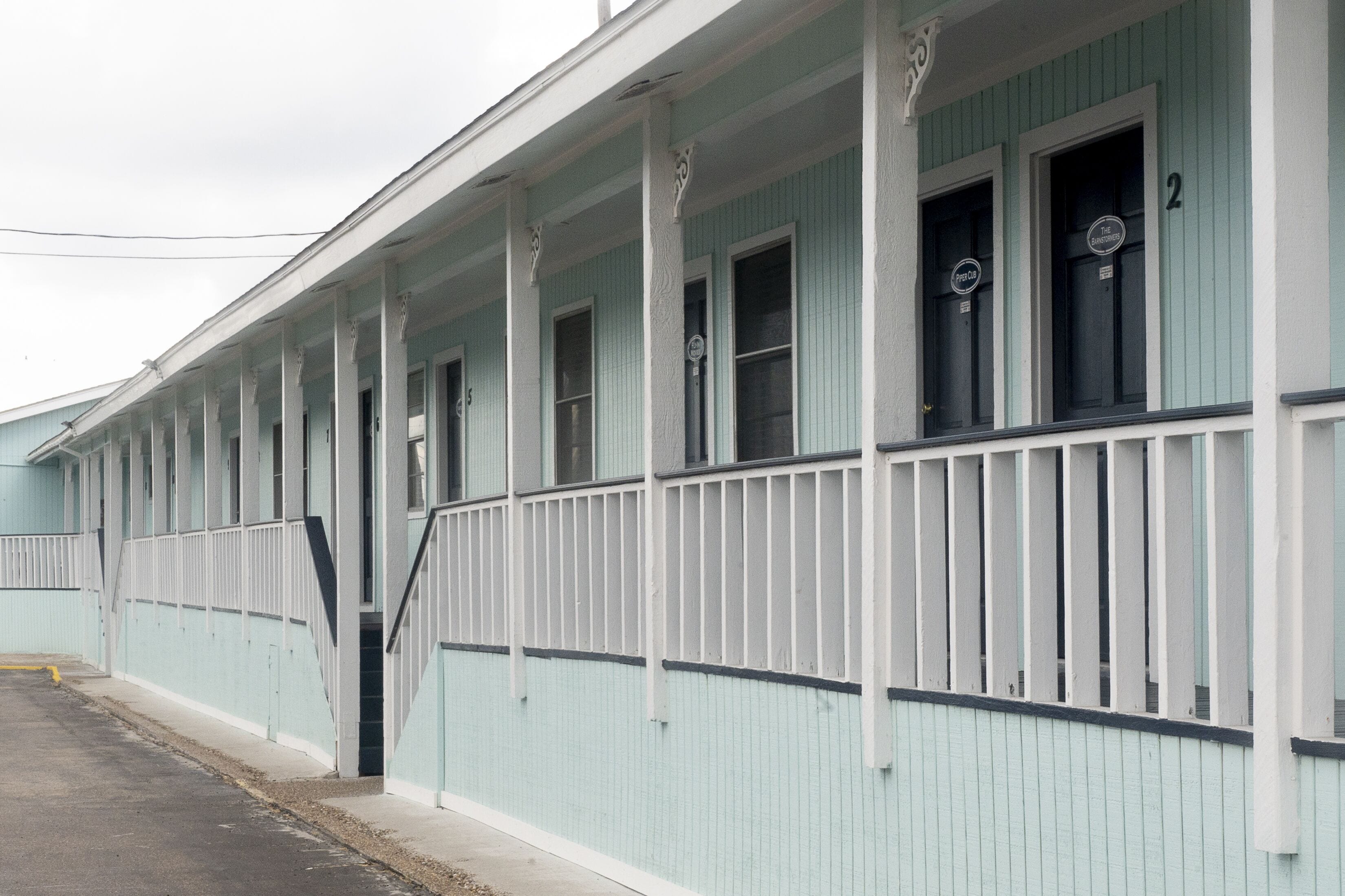 A light blue building with white trim and a covered porch.