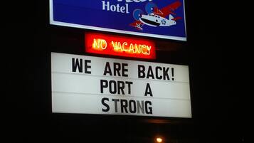 A hotel sign with "Amelia's Landing Hotel" and a message "NO VACANCY" in red letters.