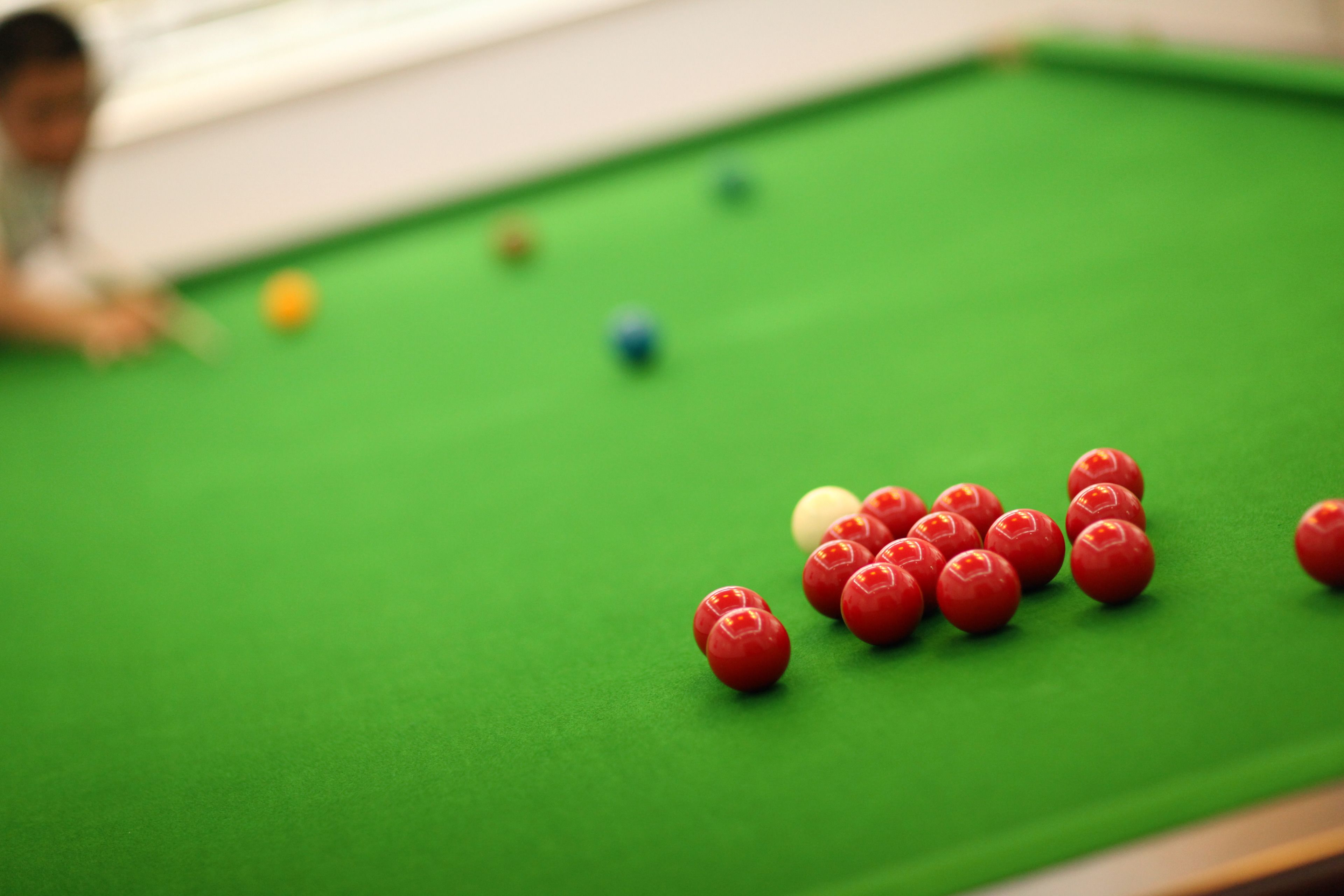 A pool table with red and yellow balls.
