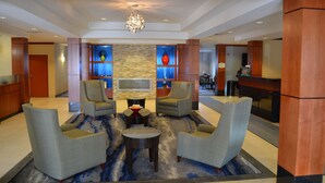 A lobby with a seating area, a TV, and a reception desk.