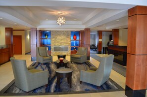 A lobby with a seating area, a TV, and a reception desk. - Fairfield Inn & Suites by Marriott Sault Ste. Marie (Sault Ste. Marie)