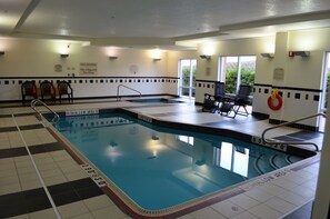 An indoor swimming pool with marked shallow and deep ends, lounge chairs, and a lifeguard station. - Fairfield Inn & Suites by Marriott Sault Ste. Marie (Sault Ste. Marie)