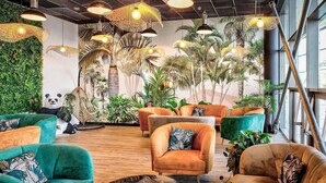Un espace de détente moderne, doté de sièges confortables, de lampes suspendues et d’un mur végétal luxuriant.