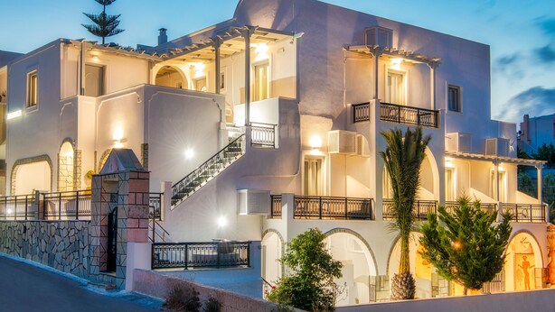 Un edificio de varios pisos con fachada de piedra, múltiples balcones y una escalera que conduce a los niveles superiores.