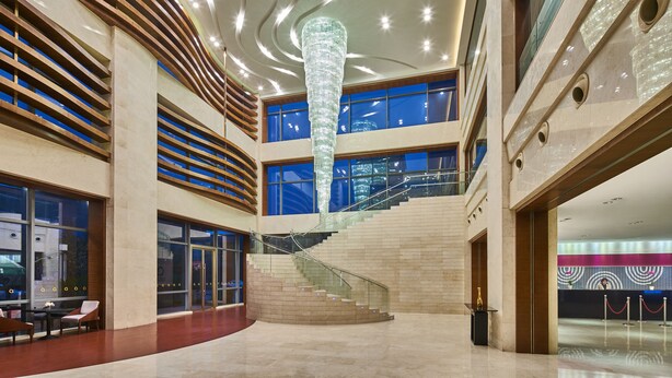 A spacious lobby with a central staircase, large windows, and a modern chandelier. - The Qube Hotel (Shanghai)