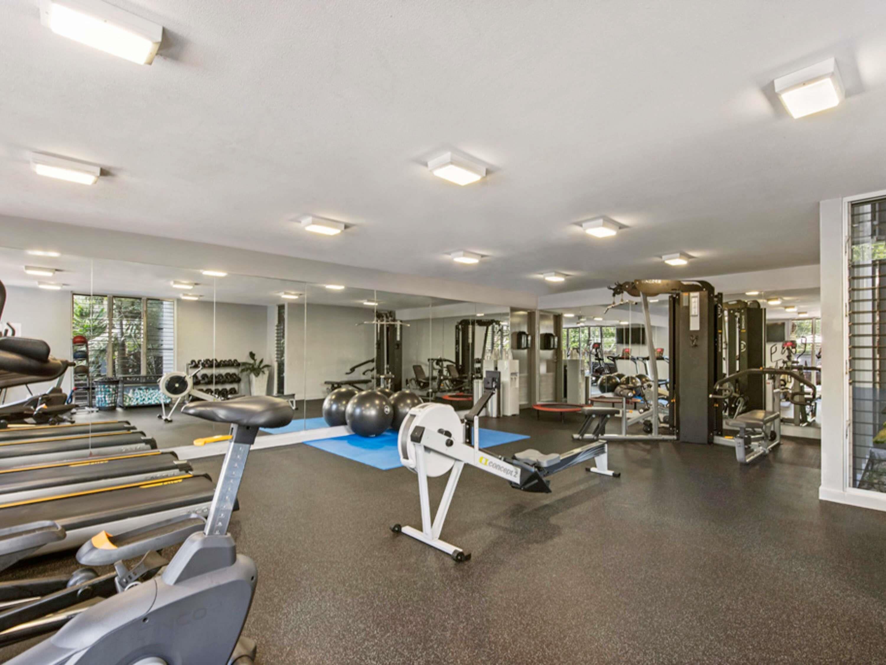 Ein Fitnessstudio mit Laufbändern, Gymb ällen und Krafttrainingsgeräten.