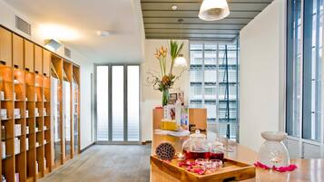 Welcome to our hotel lobby, featuring a spacious reception area with a large window offering a view of the outside, a wooden reception desk, and a unique ceiling design.