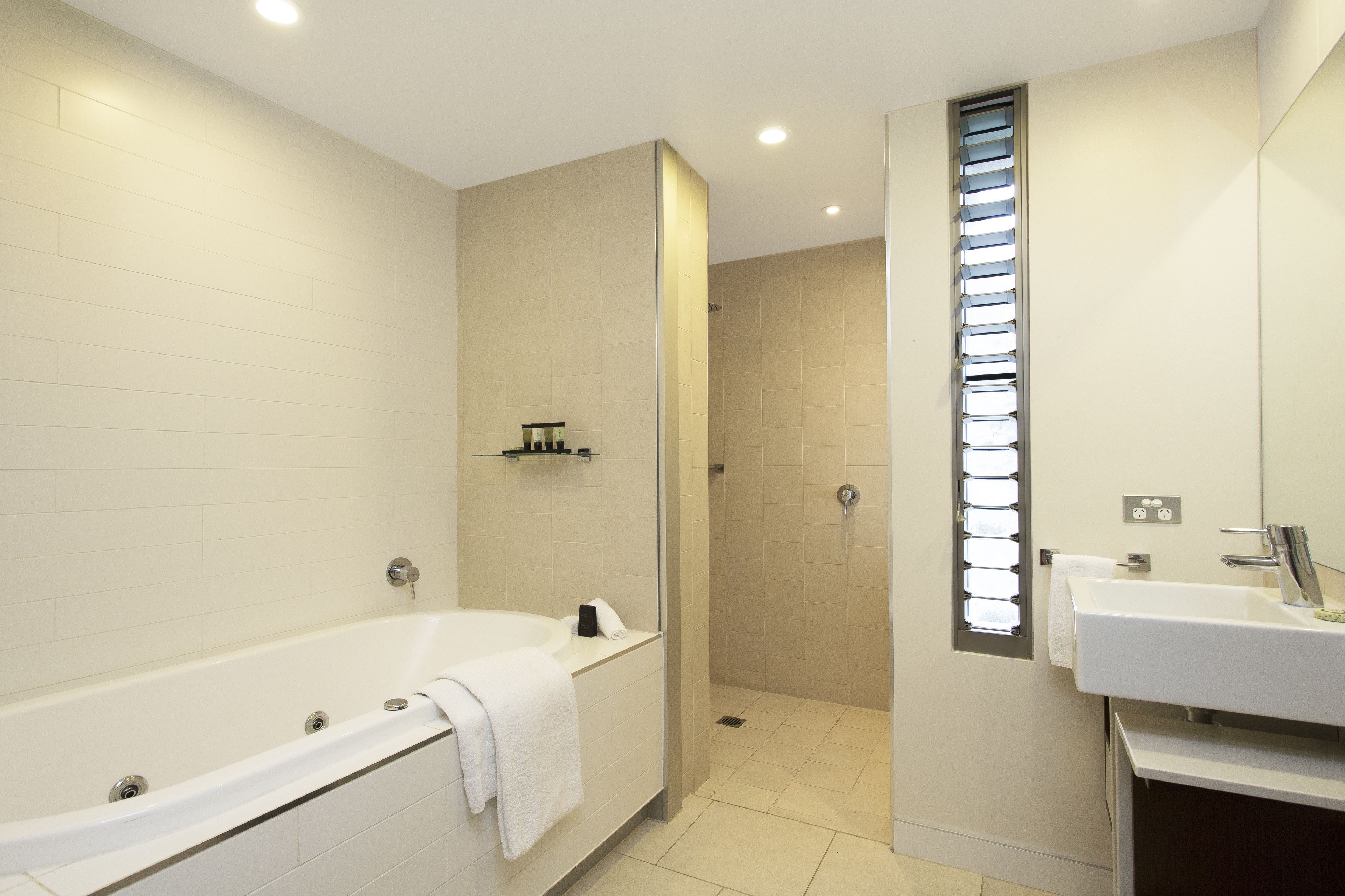 Ein modernes Badezimmer mit Badewanne, Dusche und Waschbecken.