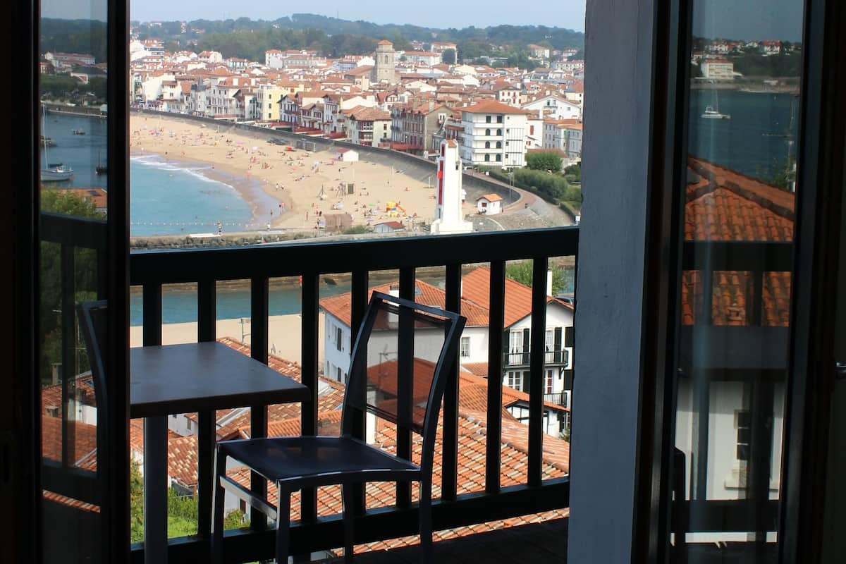 Een balkon met uitzicht op strand en stadsbeeld.