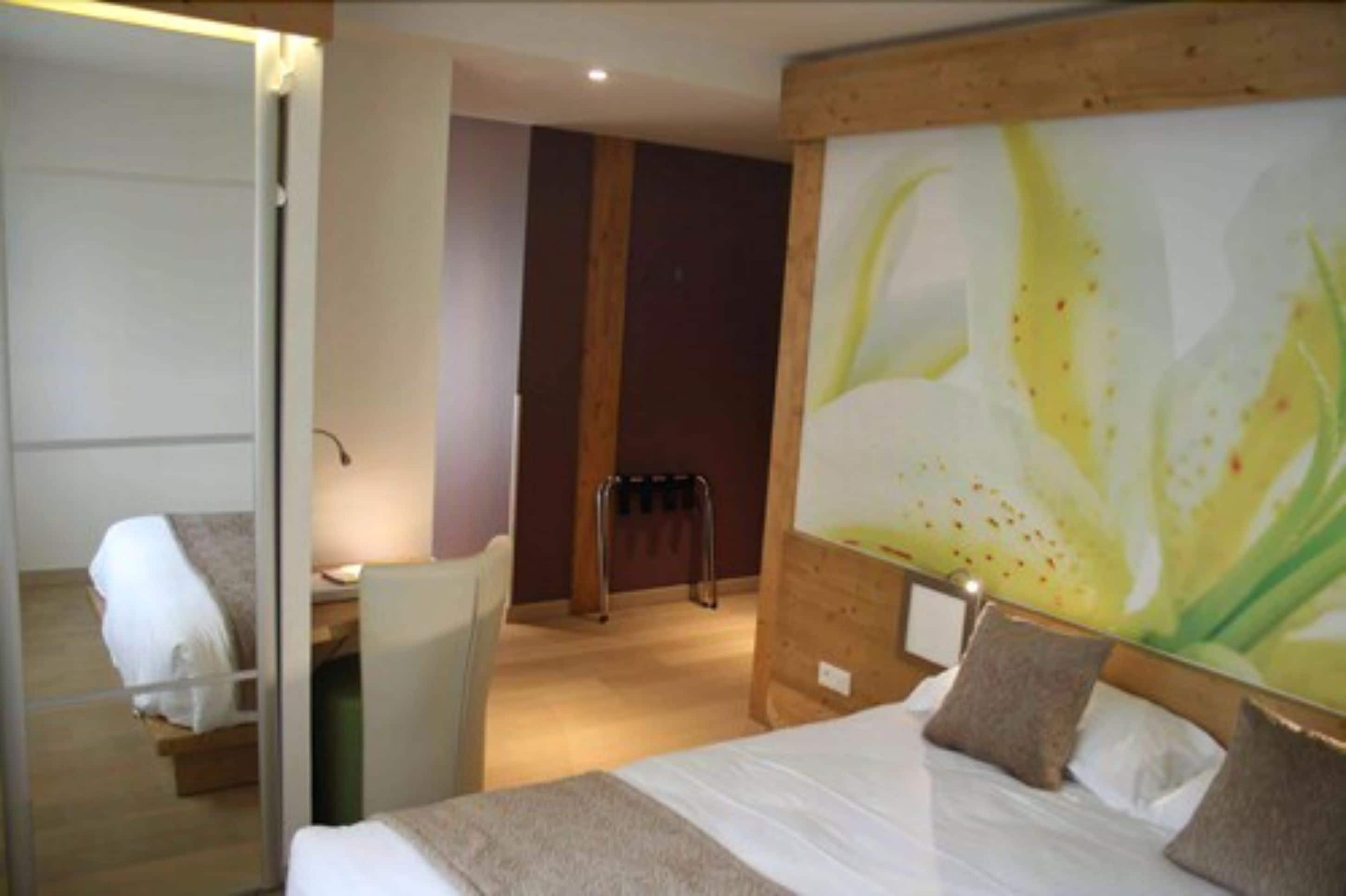 A hotel room with a bed, a desk, and a chair.