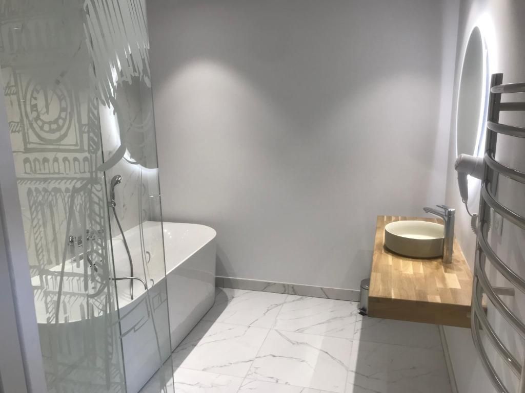 A modern bathroom with a glass-enclosed shower, a freestanding bathtub, and a wooden vanity with a sink.