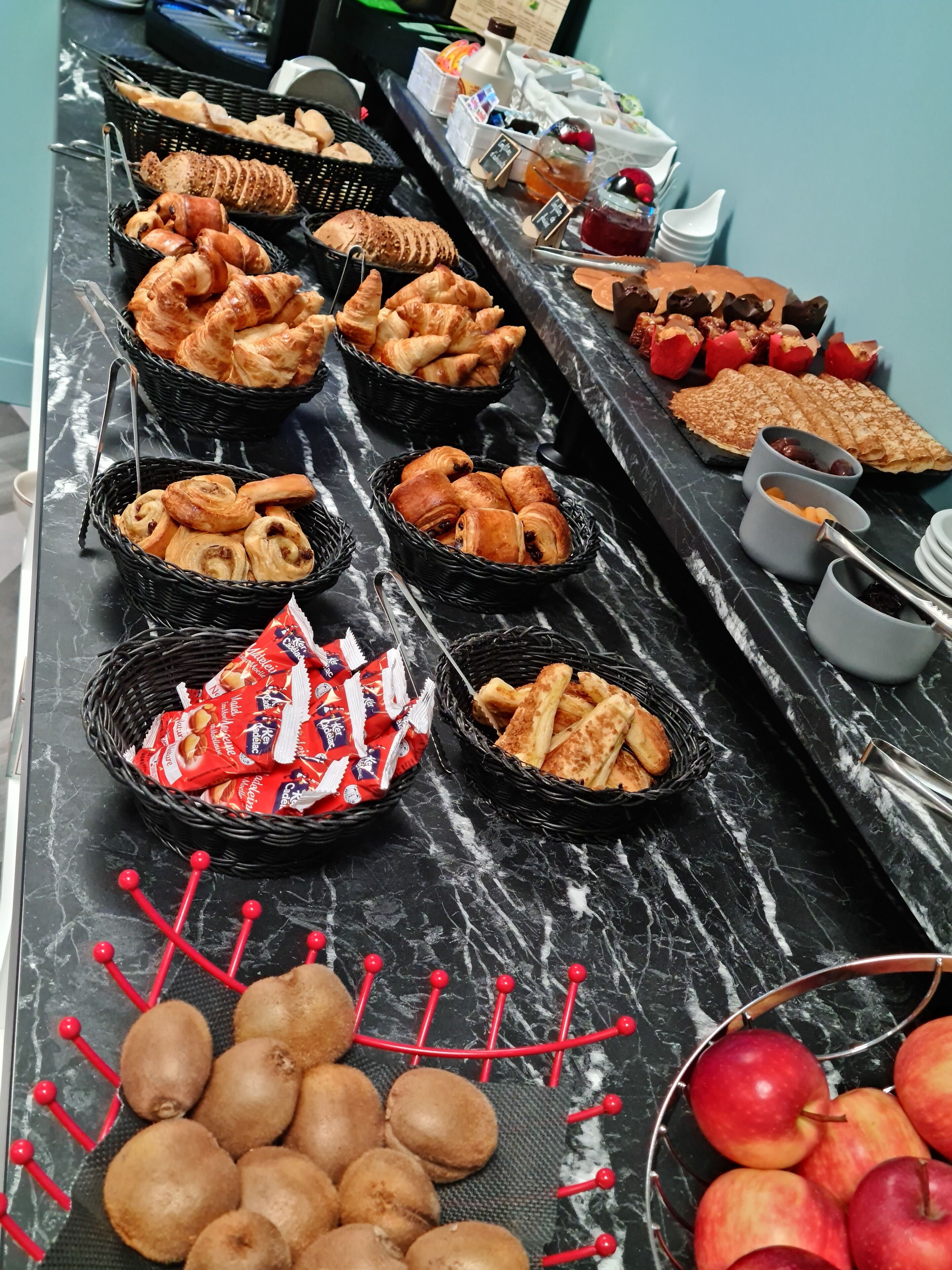 Un tavolo per buffet con diversi prodotti da forno e frutta.