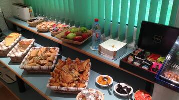 Taula de buffet amb diferents aliments i begudes.