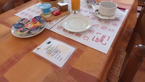 A breakfast table with croissants, yogurt, juice, and a teapot. - Citotel Aero Hotel (Le Blanc-Mesnil)