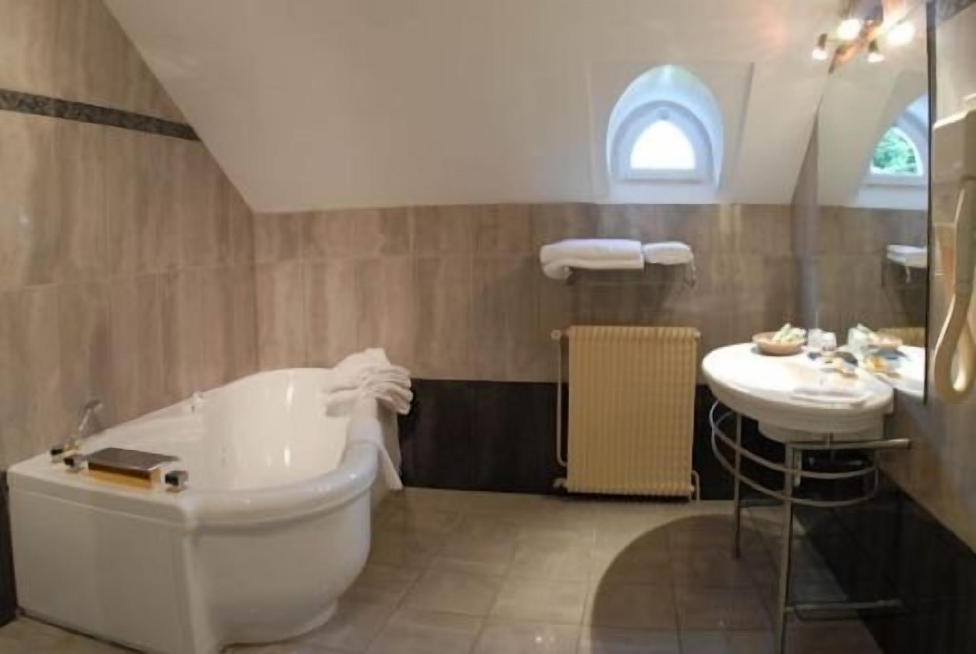 Une salle de bain avec une baignoire sur pieds, un lavabo rond et un porte-serviettes.