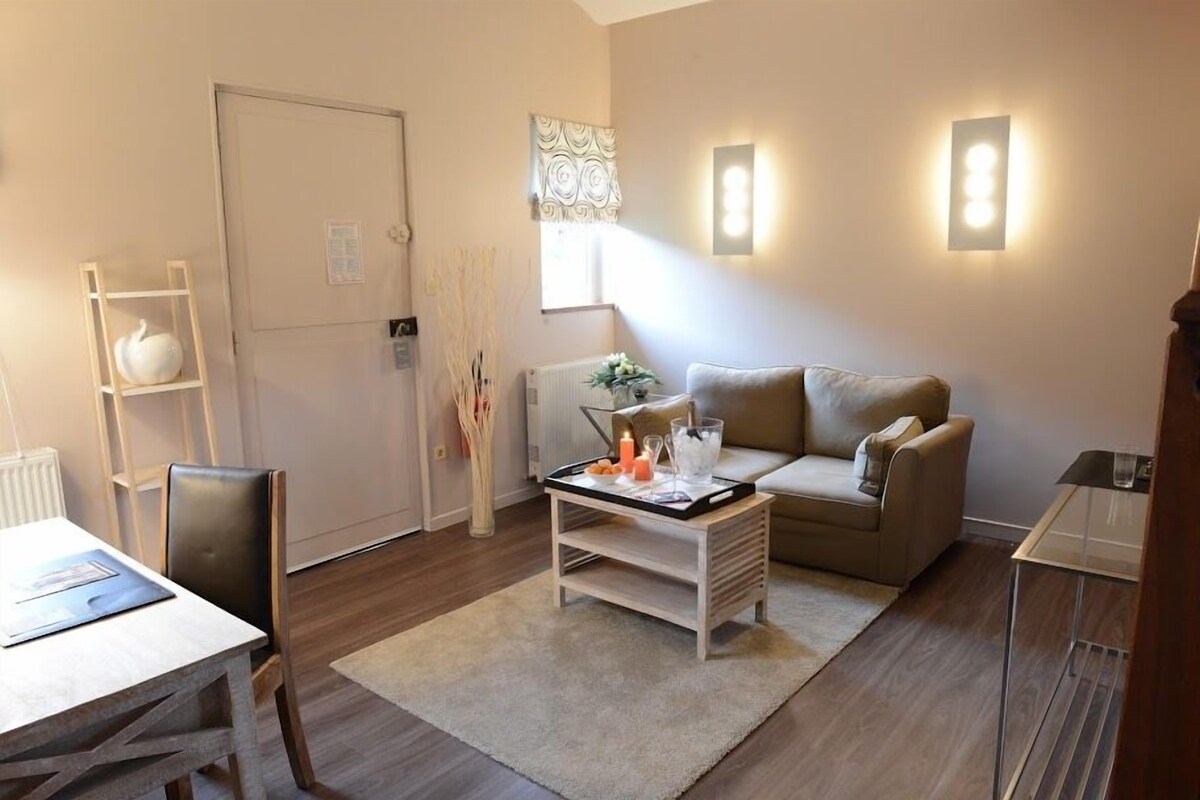 Una sala de estar con un sofá, una mesa de centro con velas, un radiador y una puerta.