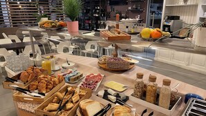 A buffet with various food items including bread, pastries, and fruits. - Citotel Le Chene Vert (Les Sables-d'Olonne)