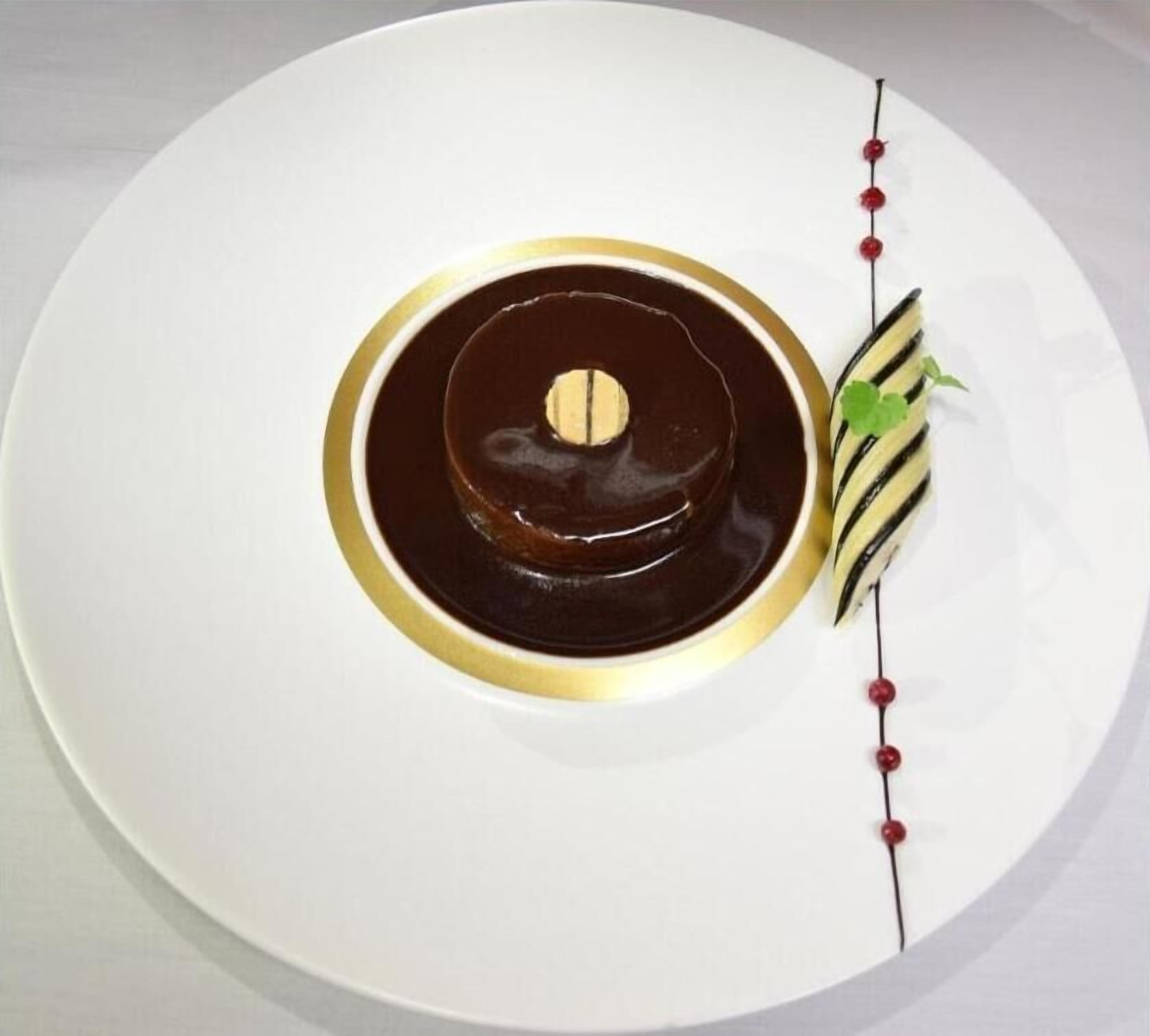 A dessert on a white plate with a gold rim.