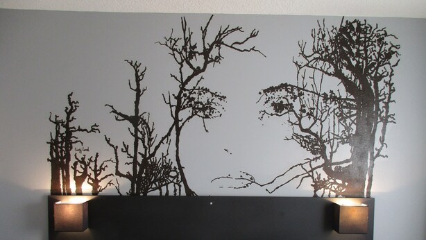 A hotel room with a bed, white bedding, a wall-mounted artwork of trees, and two bedside lamps. - Citotel Dav'hotel Jaude (Clermont-Ferrand)
