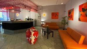 A modern lobby with a reception desk, a heart-shaped seating area, and orange sofas. - Citotel Dav'hotel Jaude (Clermont-Ferrand)