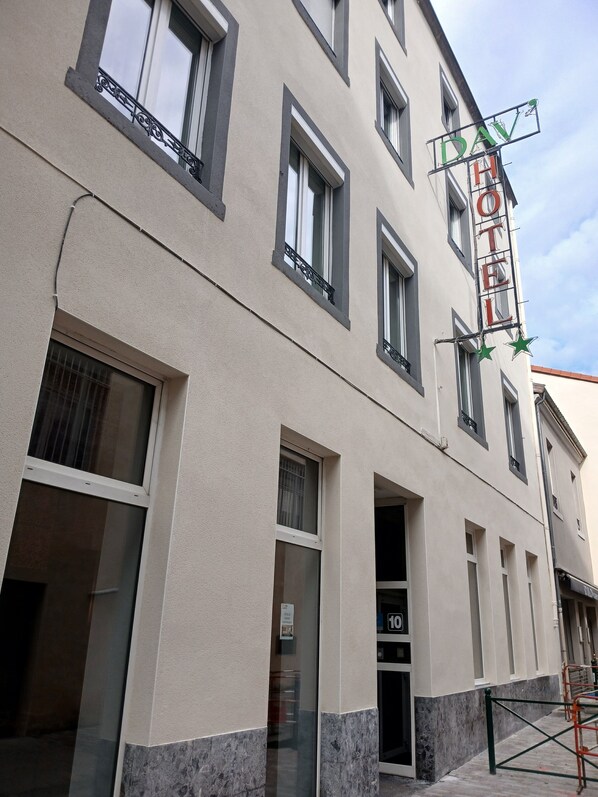 Un hotel con un letrero que dice "DAV HOTEL" y una puerta de entrada visible marcada con el número "10".