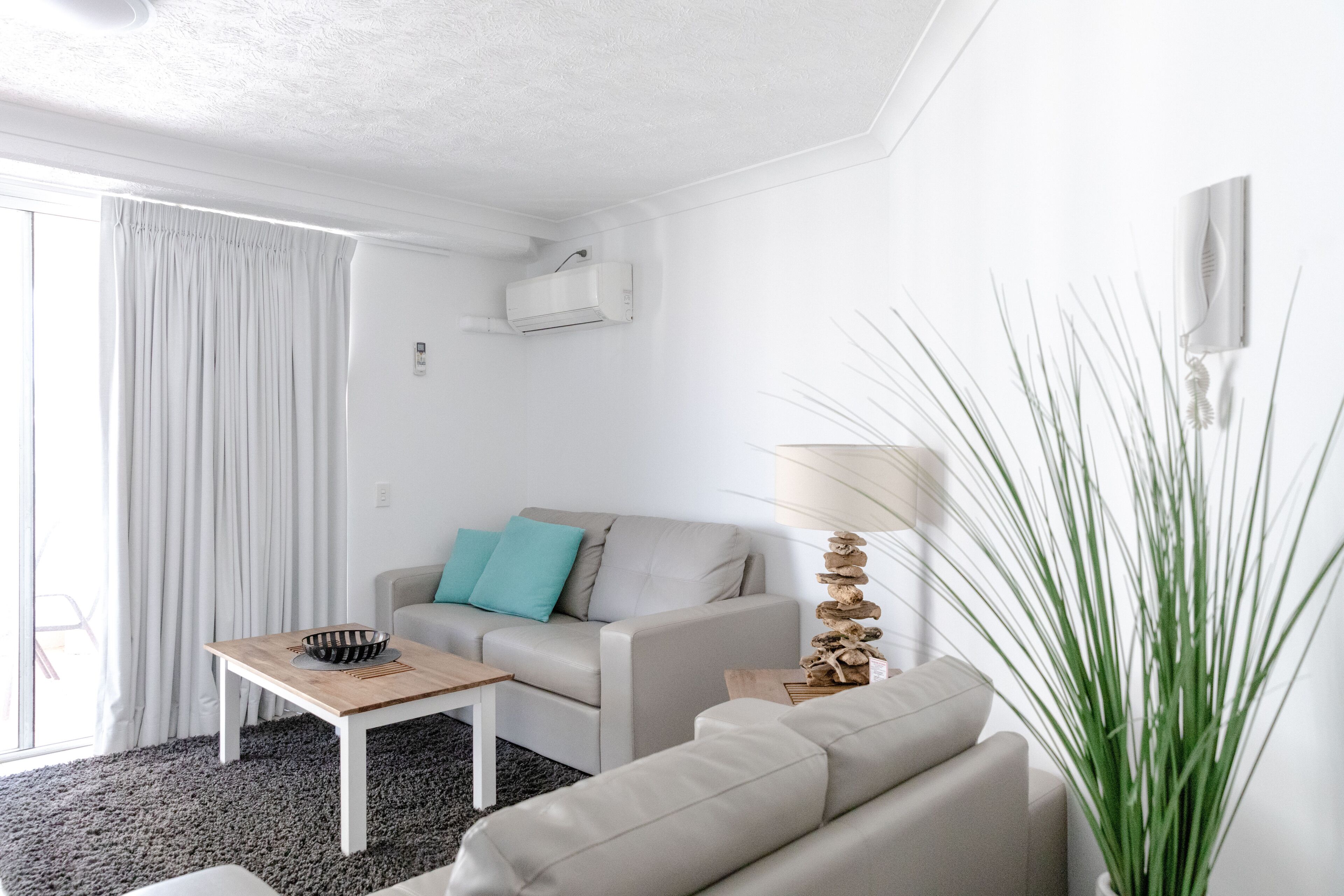 A modern living room with a sofa, a coffee table, and a lamp.