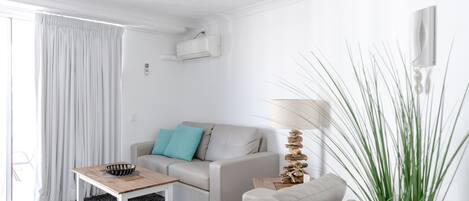 A modern living room with a sofa, a coffee table, and a lamp.