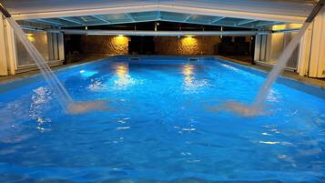 Una piscina techada, sillones reclinables de piscina