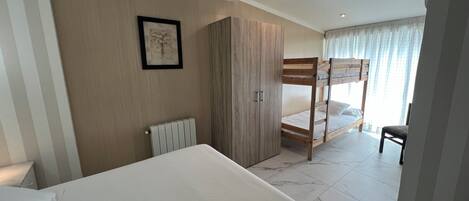 Una camera da letto con un letto a castello, un armadio, un termosifone e un quadro appeso al muro.