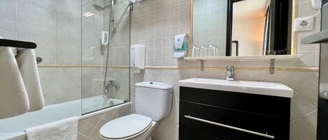 Un baño moderno con bañera, inodoro y tocador.