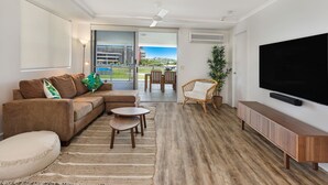 Uma sala de estar moderna com sofá, mesa de centro e aparador para TV.