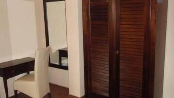 Ein Zimmer mit einem Holzschrank, einem Schreibtisch und einem Stuhl.