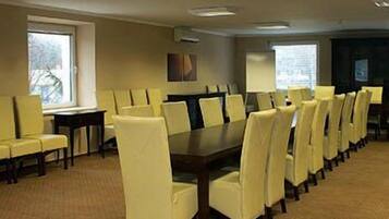 A conference room with a long table and chairs, large windows, and a carpeted floor.