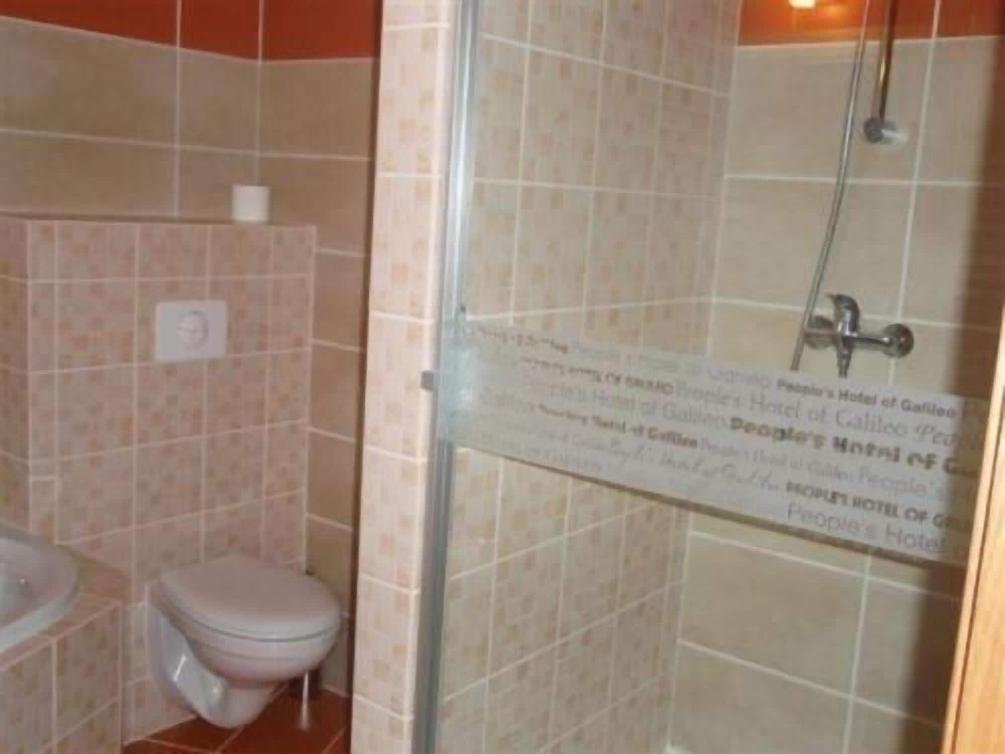 A bathroom with a toilet, sink, and shower area.