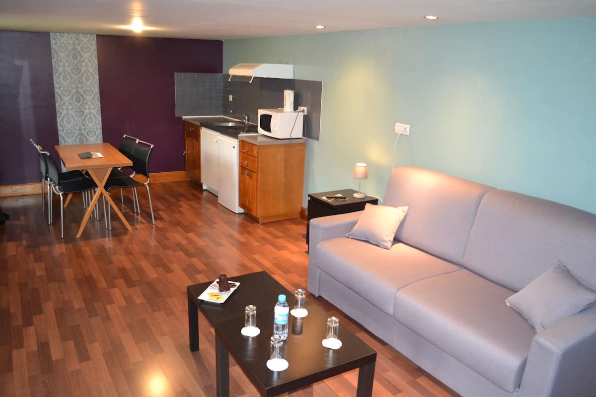 A compact living space with a kitchenette, a dining area, and a seating area.