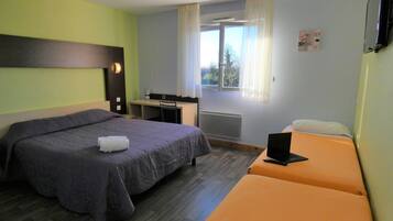 Une chambre d’hôtel avec un lit, un bureau et un ordinateur portable.