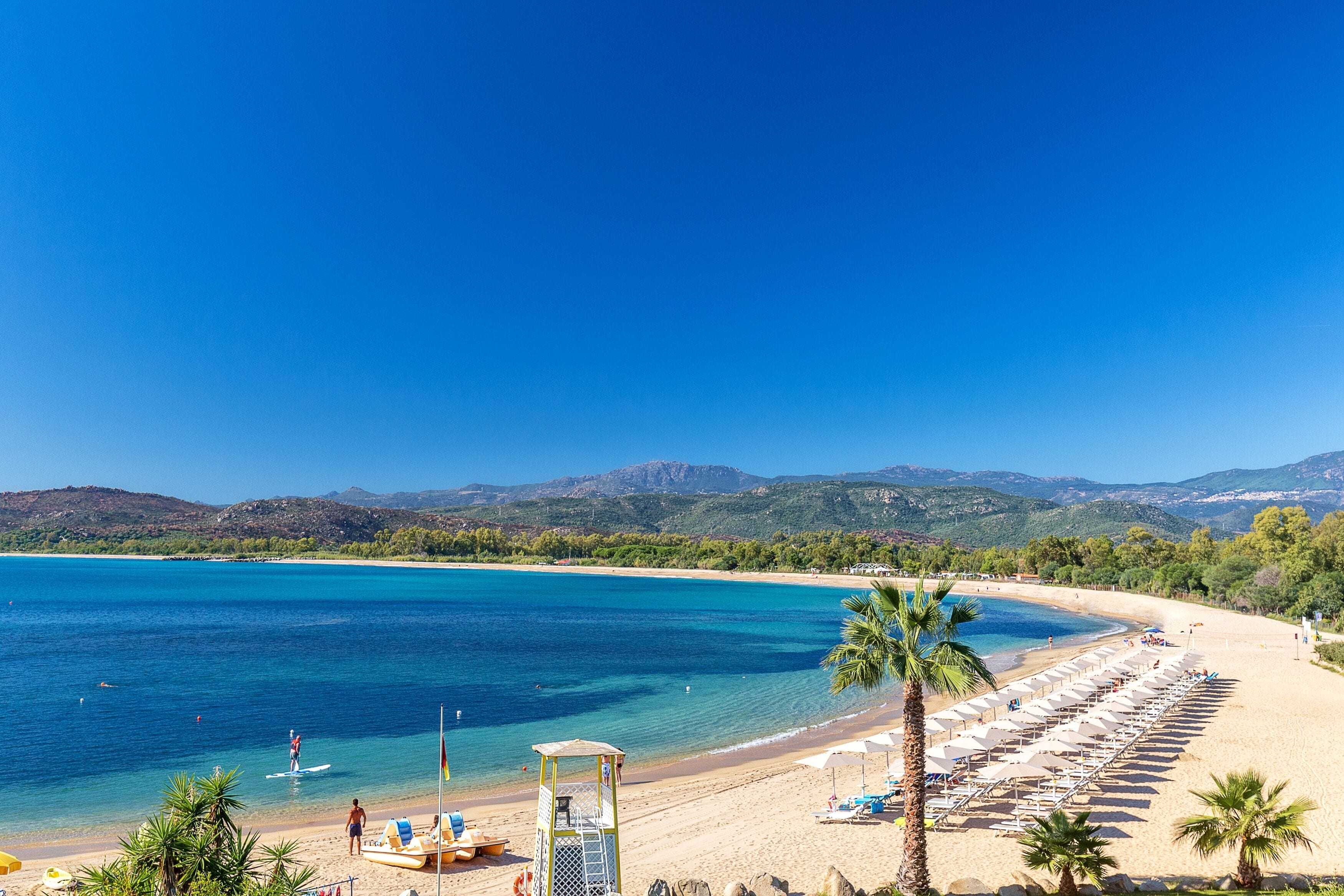 Playa privada, arena negra, sillas reclinables de playa, sombrillas