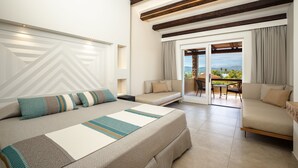 A modern hotel room with a large bed, a sofa, and a balcony with a view. - Hotel Club Saraceno (Tortoli)