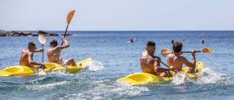 A group of people kayaking on a calm sea.