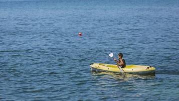 A person kayaking on a calm body of water.