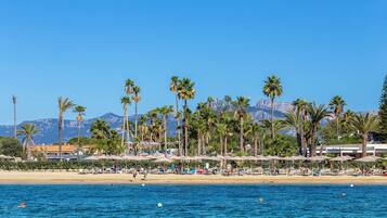 Privatstrand, schwarzer Sandstrand, Liegestühle, Sonnenschirme