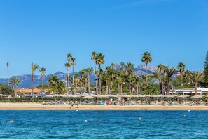 Plage privée, sable noir, chaises longues, parasols