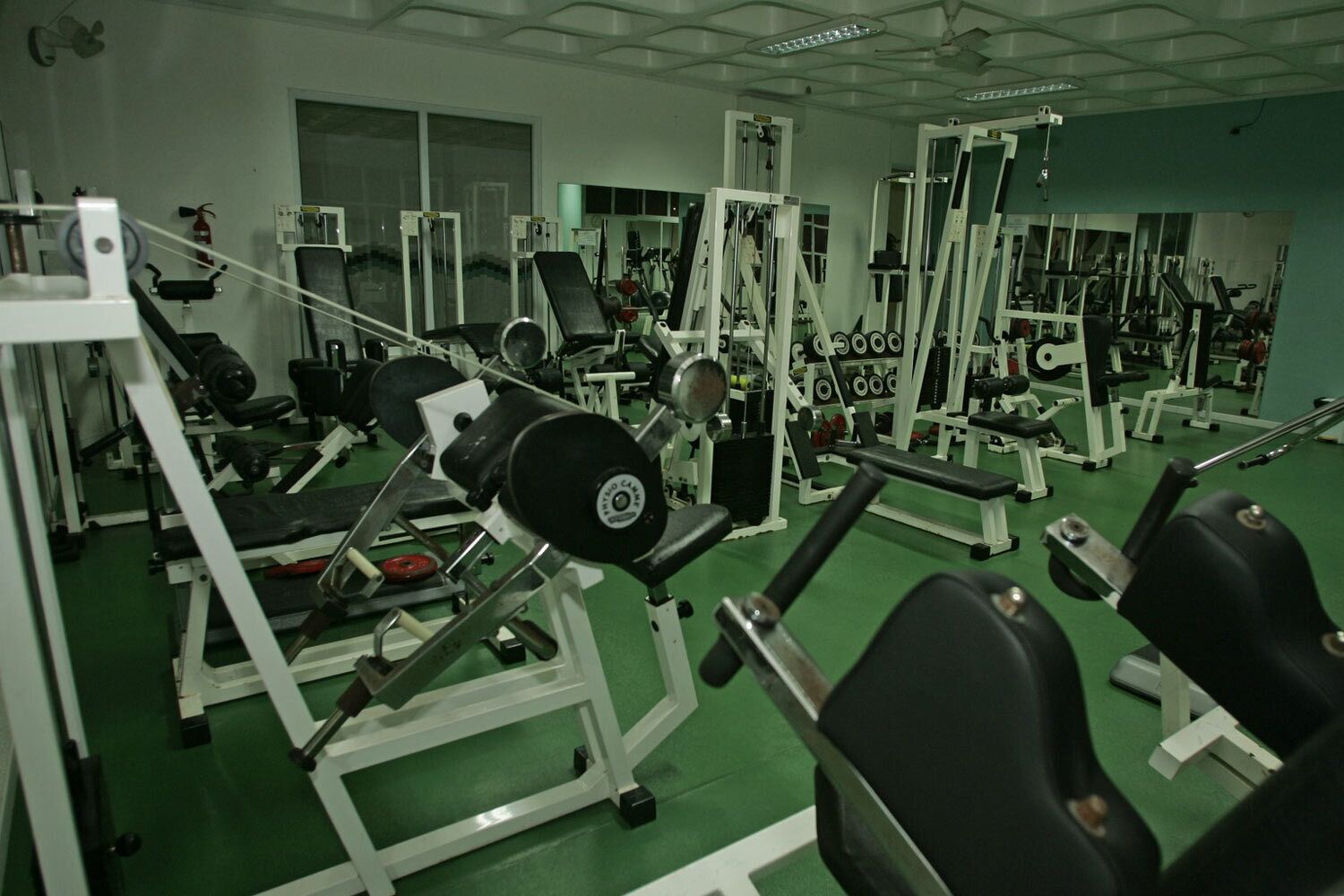 A gym with various exercise equipment, including weight machines and free weights.