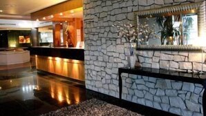 Um saguão com parede de pedra e balcão de recepção.
