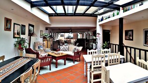 Amplia sala de estar con techo alto y tragaluces, amueblada con muebles de madera y una mesa de centro.