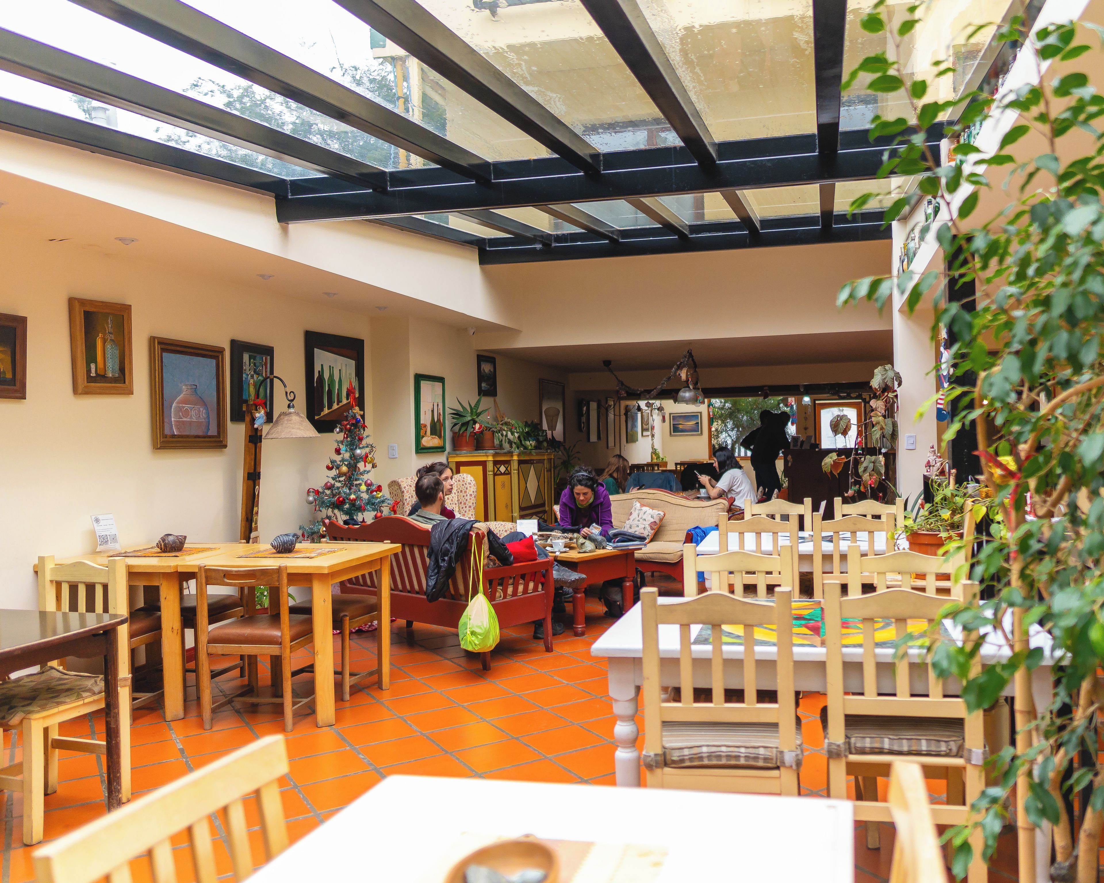 A café with indoor seating, a Christmas tree, and artwork on the walls.