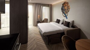 A hotel room with a large bed, a desk, a chair, and a wall-mounted artwork. - Van Der Valk Hotel Beveren (Beveren)