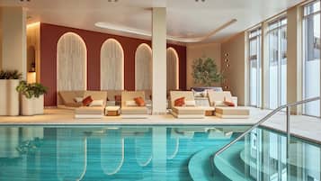 Una piscina techada, sillones reclinables de piscina