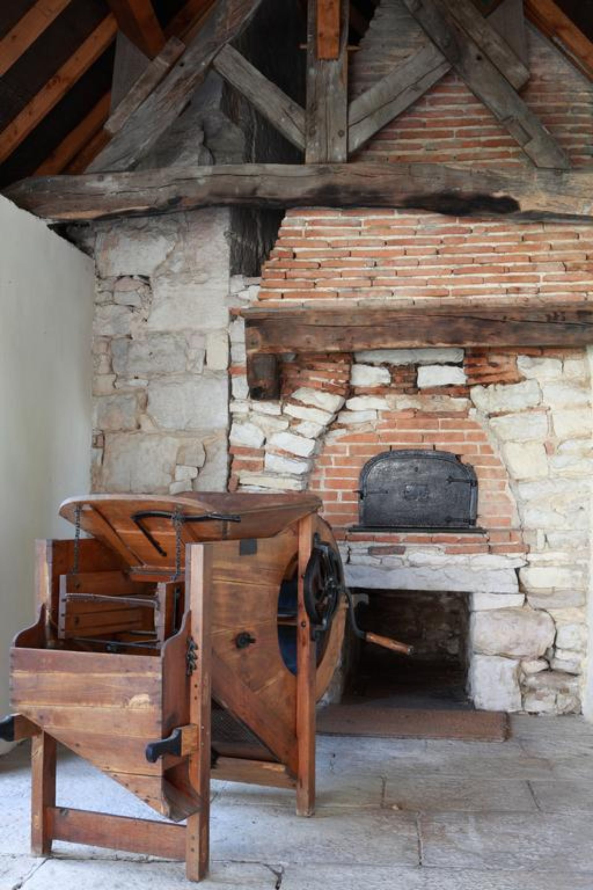 Una chimenea rústica de piedra con un banco de madera al frente.